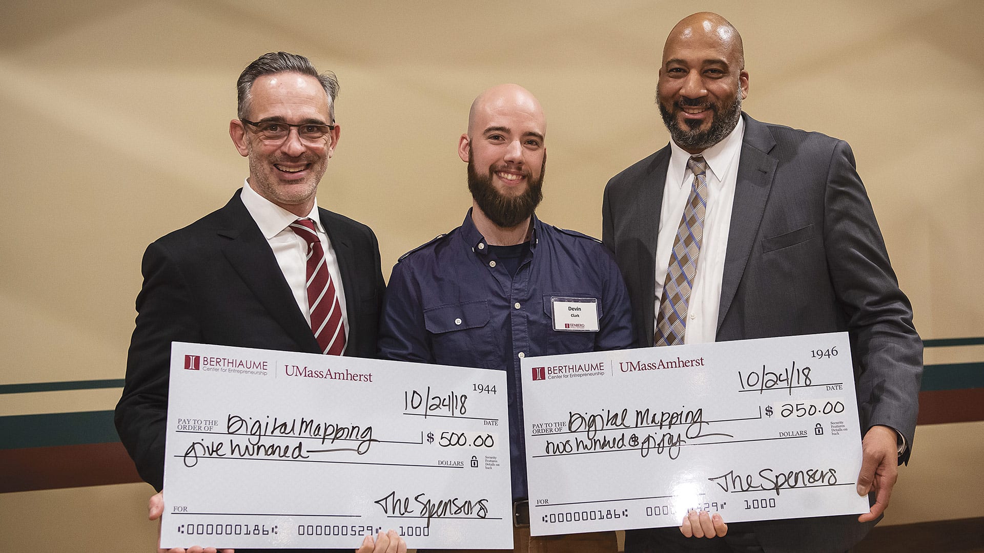 Tom Moliterno (left) and Gregory Brand (right) present the third prize in the Minute Pitch competition to Devin Clark.