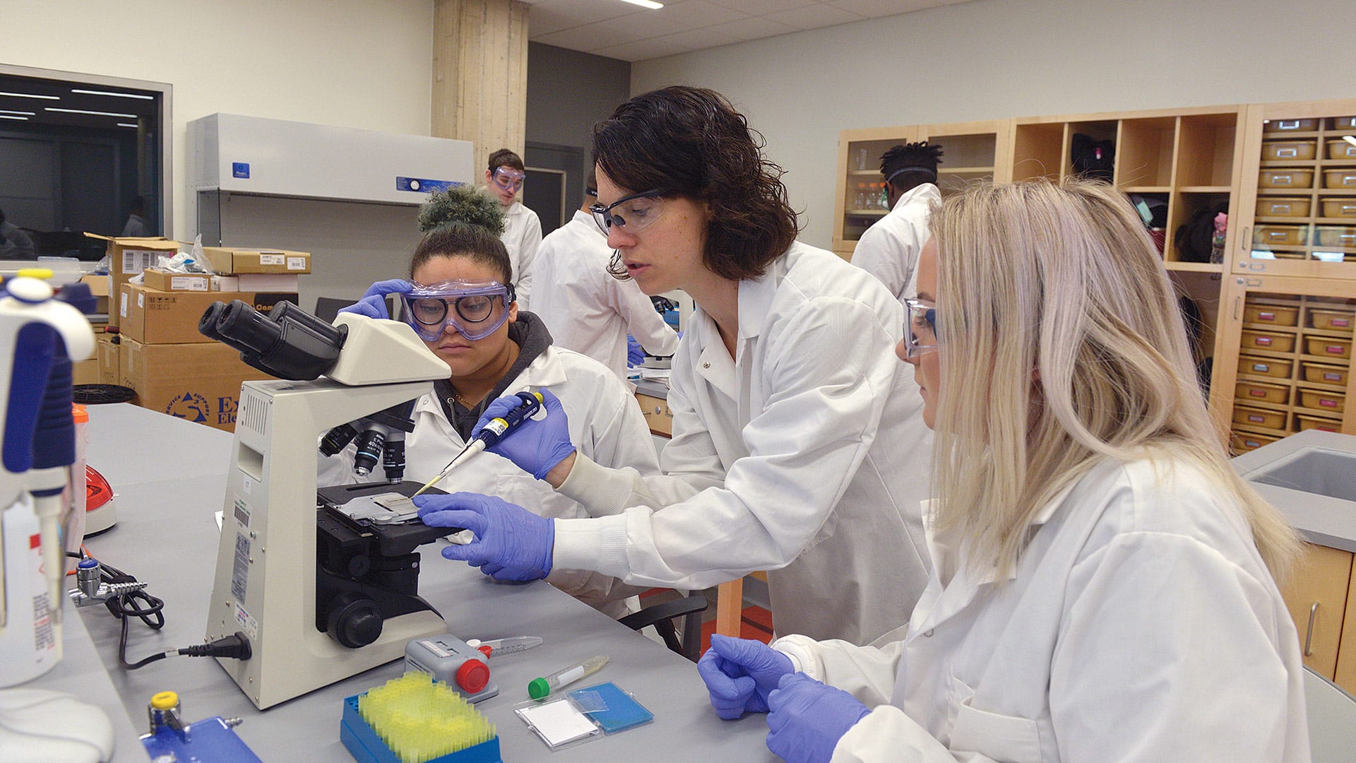 Emily Rabinsky guides two HCC students in a lab project.