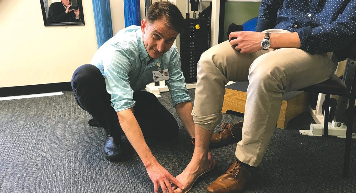 Terrence McKeon demonstrates an orthotic insert for a patient.