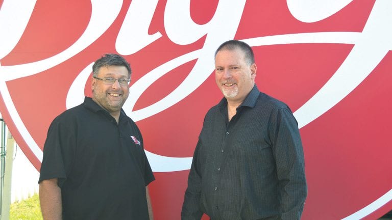 Dan Renzi, left, and his brother, John, stand in front of a new sign made for Big Y.