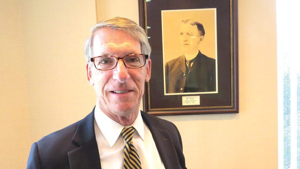 John Dowd Jr., seen here next to a photo of the company’s founder, Joseph Dowd