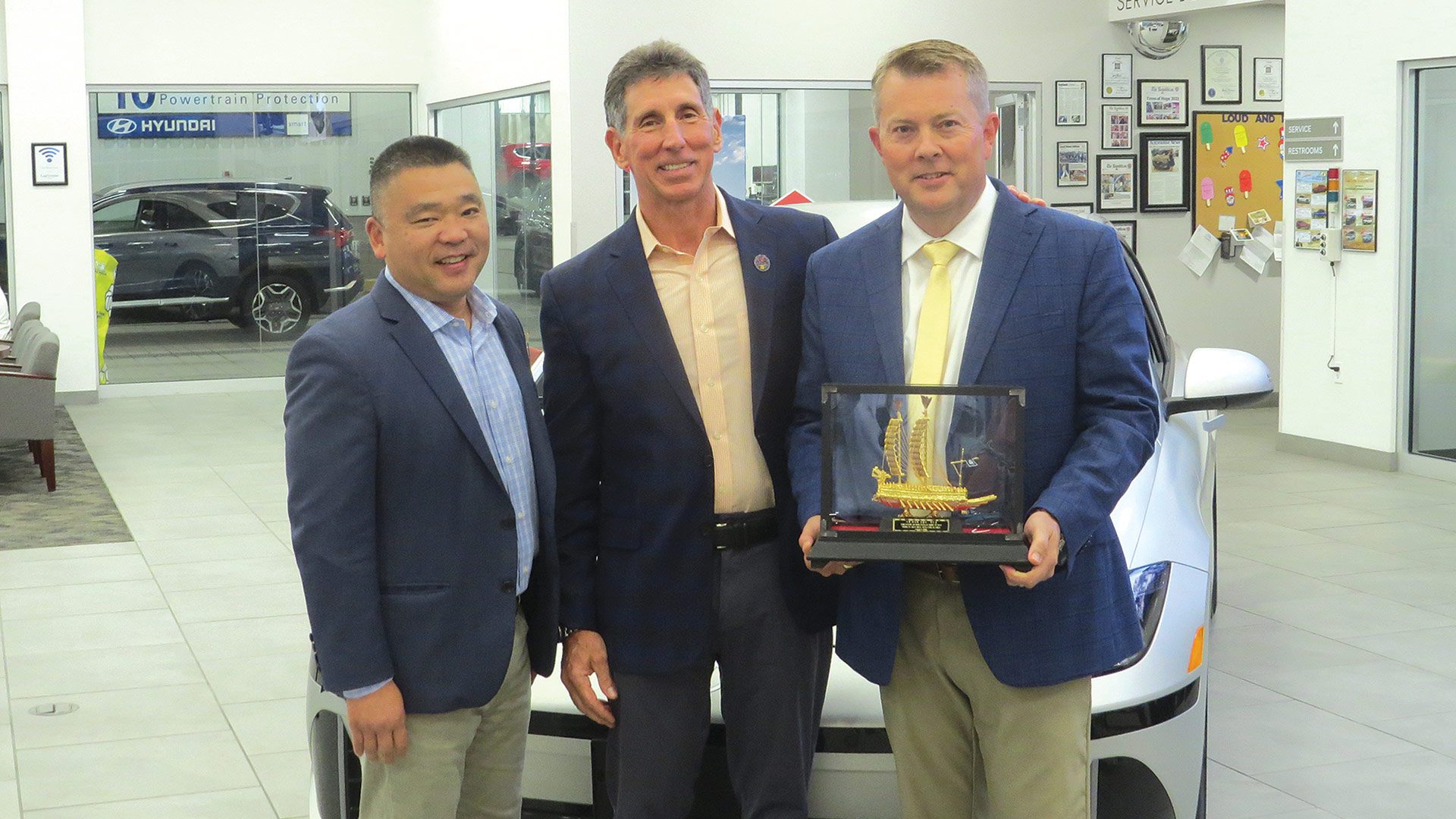 from left, Bob Kim, Hyundai’s vice president of National Sales, presents the Global Dealer Award to Gary Rome, president and CEO of Gary Rome Auto Group, and Kevin Schechterle, general manager of Gary Rome Hyundai