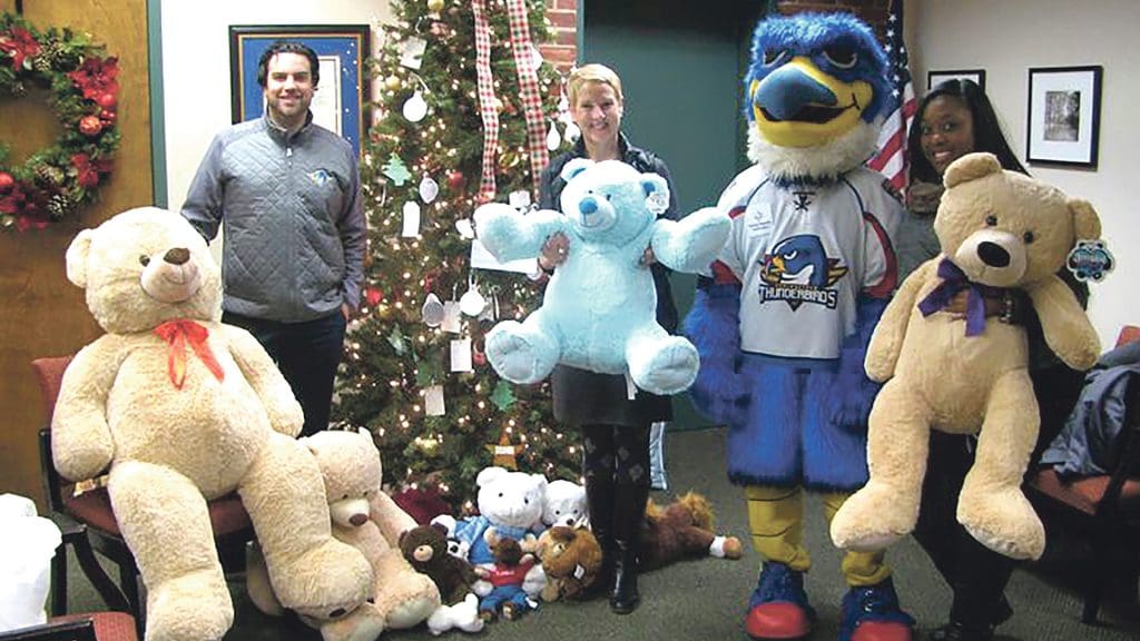 Kim Lee with Springfield Thunderbirds President Nate Costa and some teddy bears donated to the Center for Human Development’s youth-serving programs by the team through its teddy-bear drive.