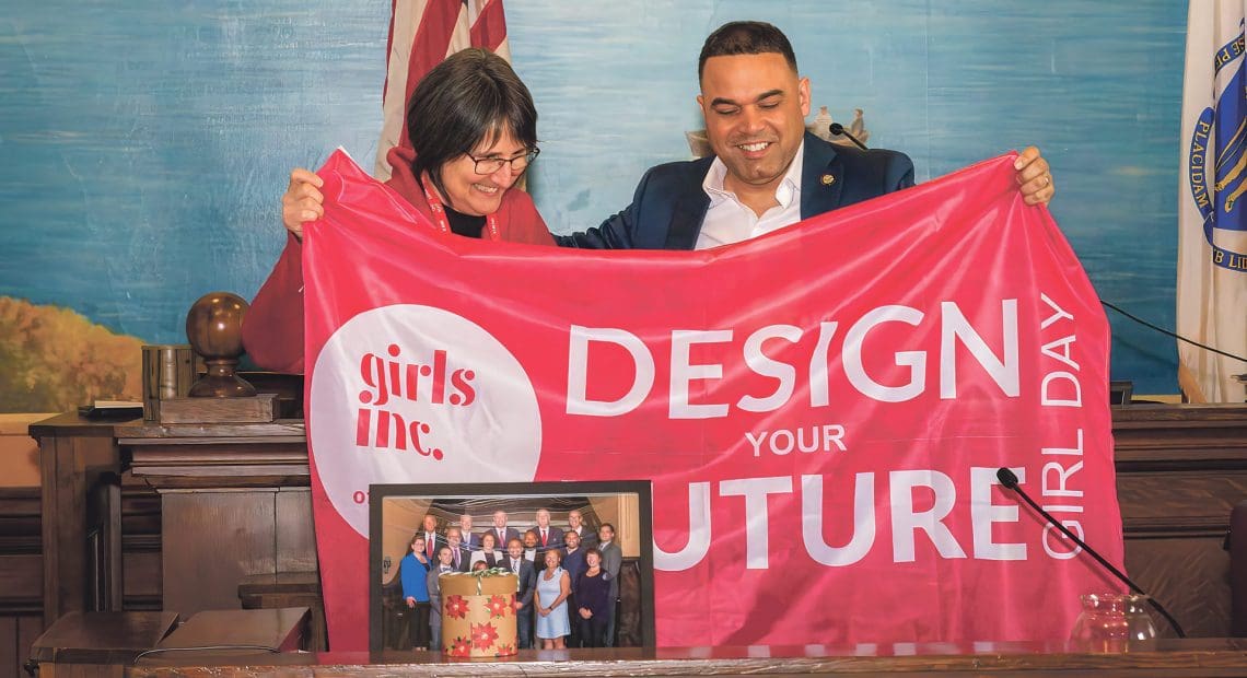 Holyoke Mayor Joshua Garcia and Suzanne Parker, executive director of Girls Inc. of the Valley, unveil the Girl Day flag