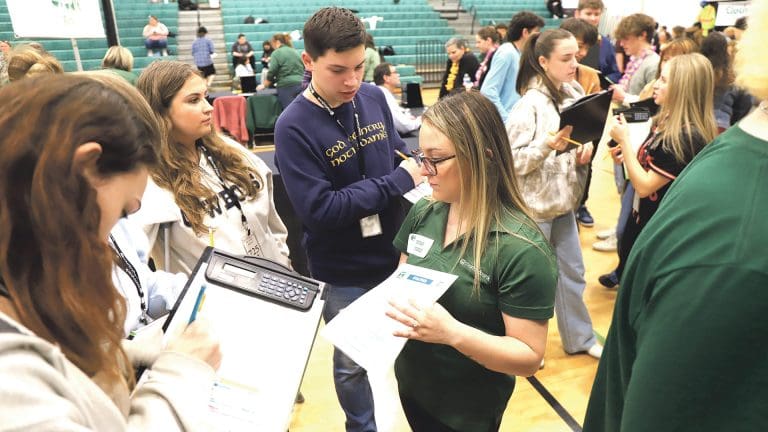 Country Bank team members help high-school seniors navigate a Credit for Life Fair.