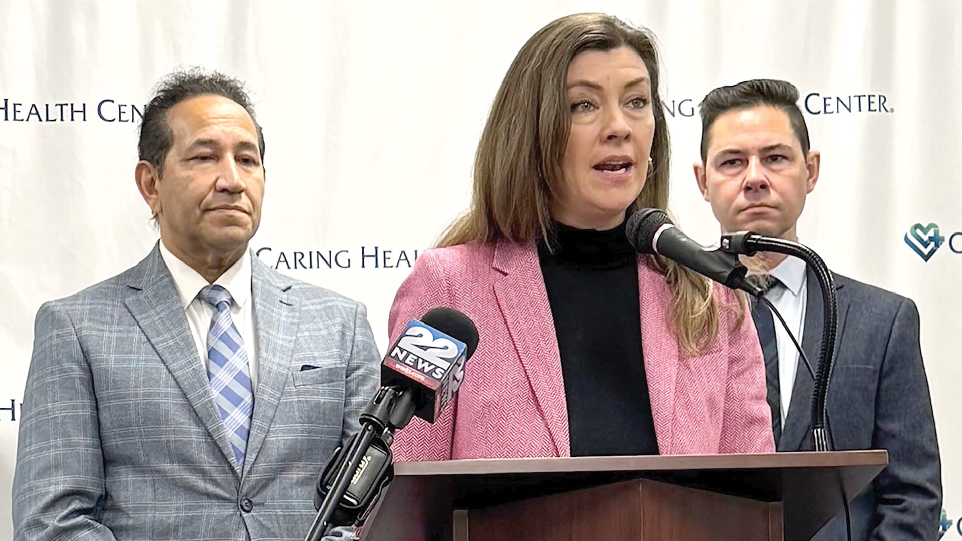 Pictured: Health Connector Executive Director Audrey Morse Gasteier (center) speaks at the press conference as state Rep. Carlos Gonzalez (left) and state Sen. Jacob Oliviera (right) listen. Cristina Huebner Torres, chief executive vice president, Strategy & Research Officer at Caring Health Center, also addressed the attendees.