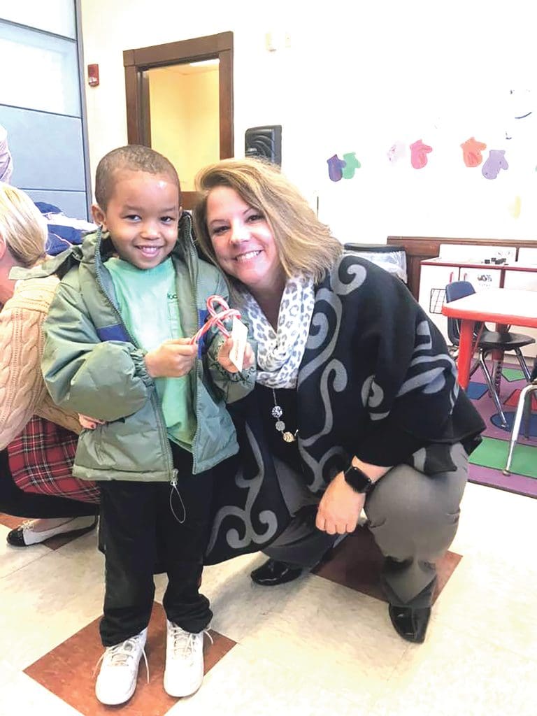 Julie Quink spends a moment with a Square One student as winter coats are distributed as part of Operation Warm.